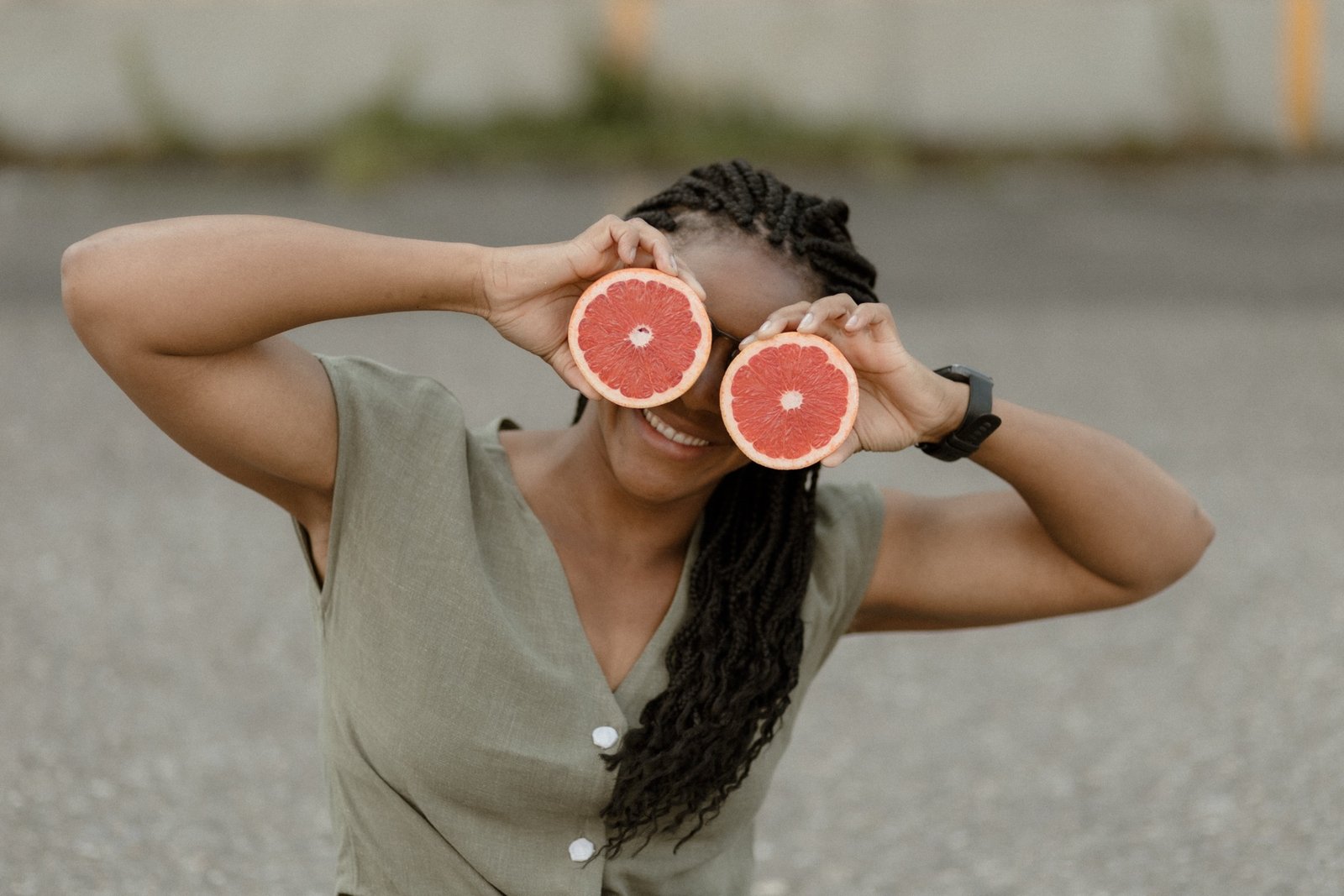 Lautana hält lachend zwei Grapefruithälften vor die Augen